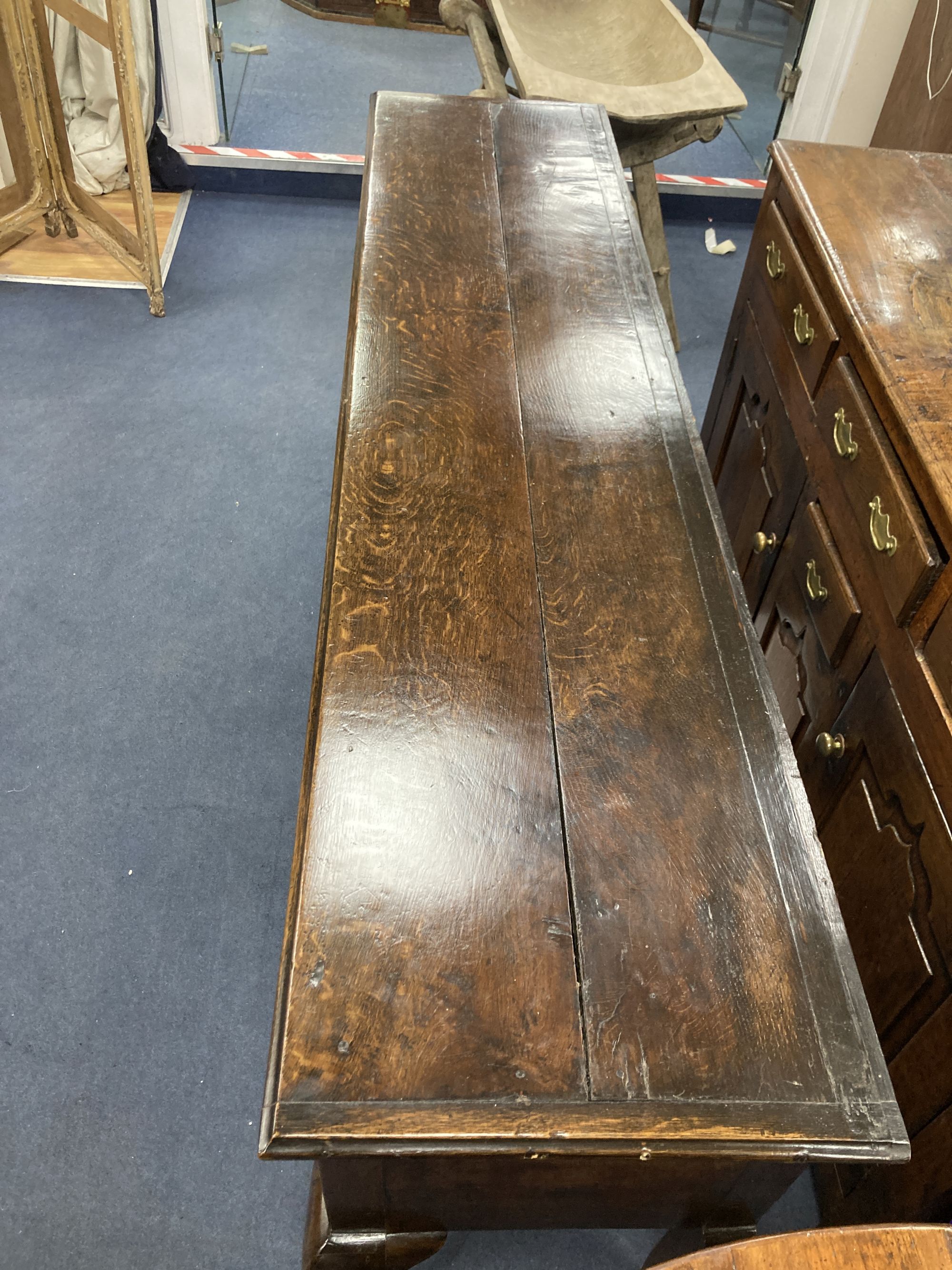 A late 17th century oak dresser base on cabriole front legs, length 180cm, depth 43cm, height 77cm